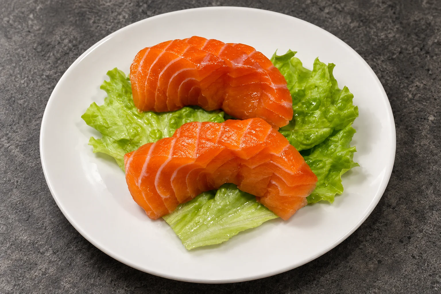 Salmon sashimi on lettuce leaves, white plate, dark concrete background.