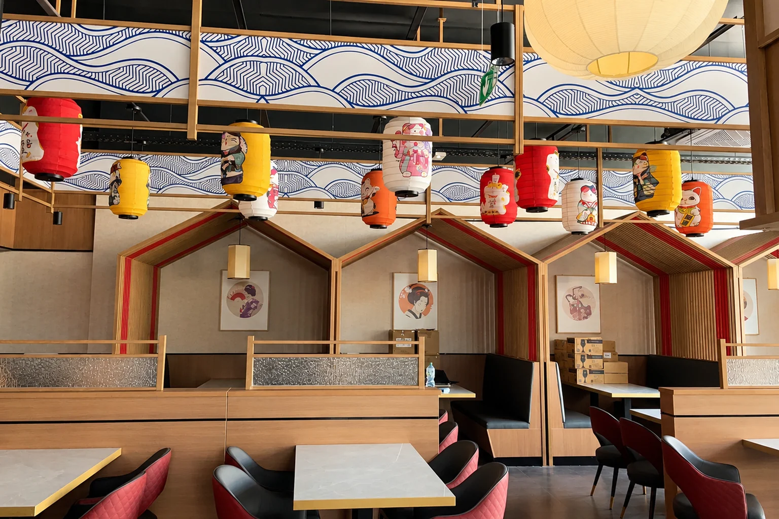 Row of wooden house-shaped booths with tables and chairs, lanterns on the ceiling.
